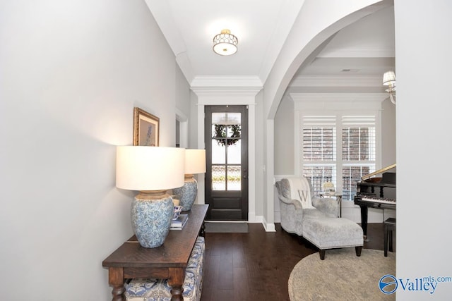 foyer entrance featuring arched walkways, hardwood / wood-style floors, and crown molding