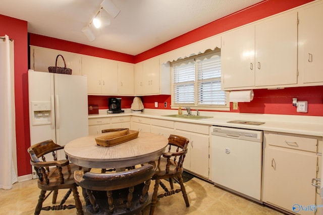 kitchen featuring track lighting, white cabinets, white appliances, and sink