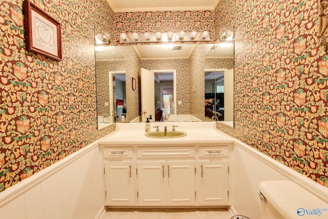 bathroom with toilet, crown molding, and vanity