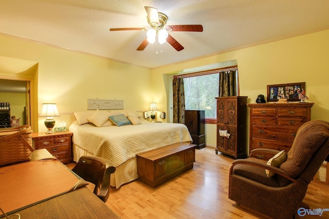 bedroom featuring ceiling fan, a textured ceiling, and light hardwood / wood-style flooring