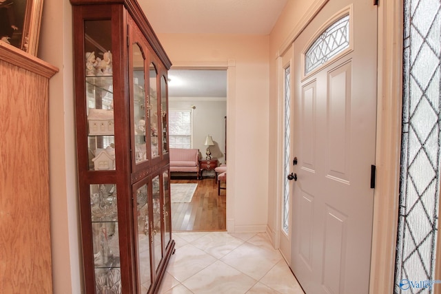 foyer entrance featuring light hardwood / wood-style floors and ornamental molding