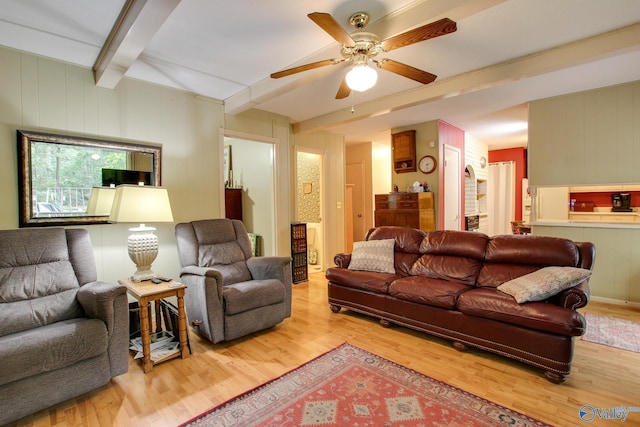 living room with light wood-type flooring, ceiling fan, and beamed ceiling