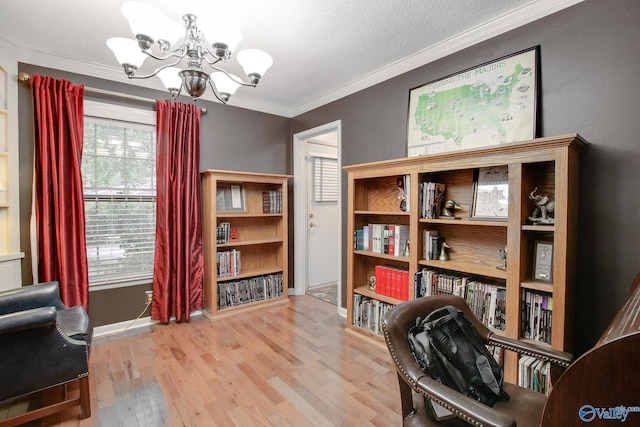 sitting room featuring ornamental molding, light hardwood / wood-style flooring, and an inviting chandelier