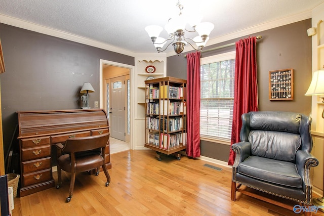 home office featuring ornamental molding, a textured ceiling, a notable chandelier, and light hardwood / wood-style flooring