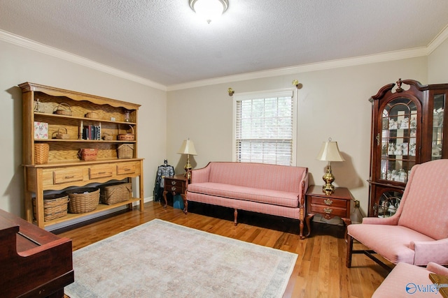 living room with wood-type flooring, ornamental molding, and a textured ceiling