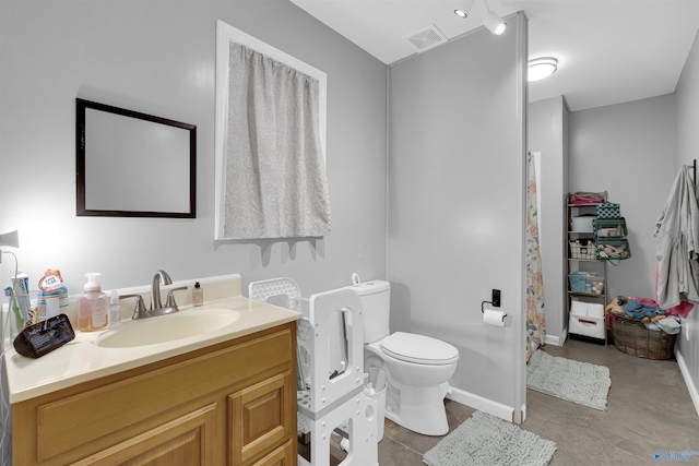 bathroom featuring vanity, concrete flooring, and toilet