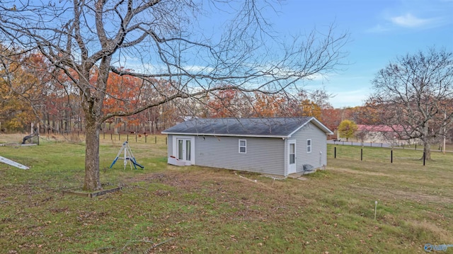 view of property exterior with an outdoor structure and a yard