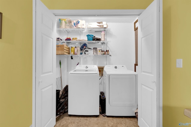 clothes washing area featuring light tile patterned floors and washing machine and clothes dryer