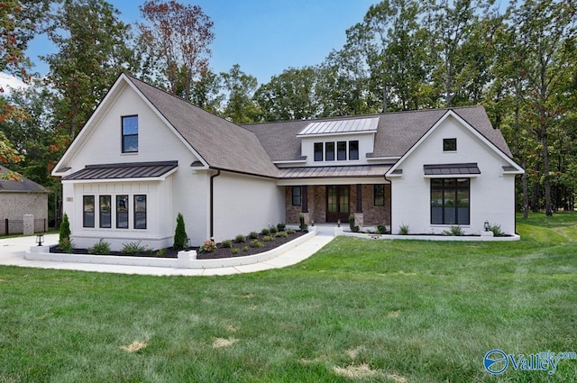 modern farmhouse style home with metal roof, a front lawn, and a standing seam roof