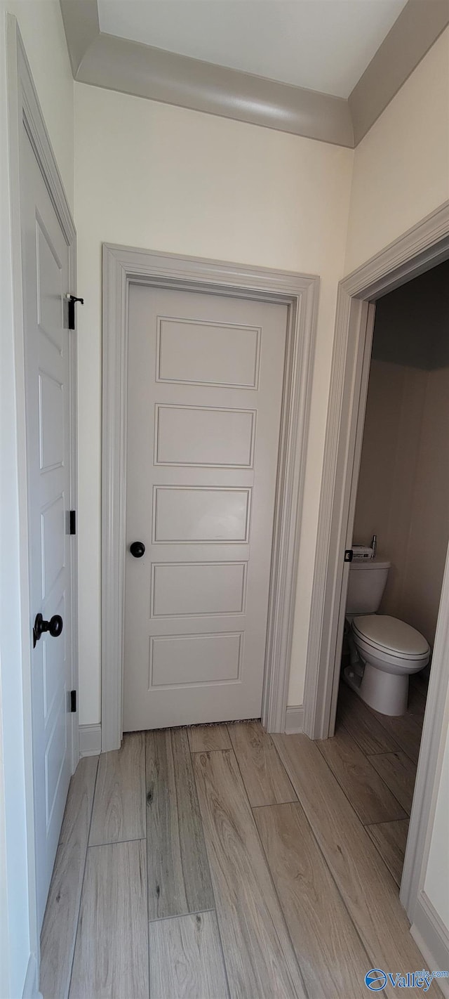 interior space with hardwood / wood-style floors and toilet