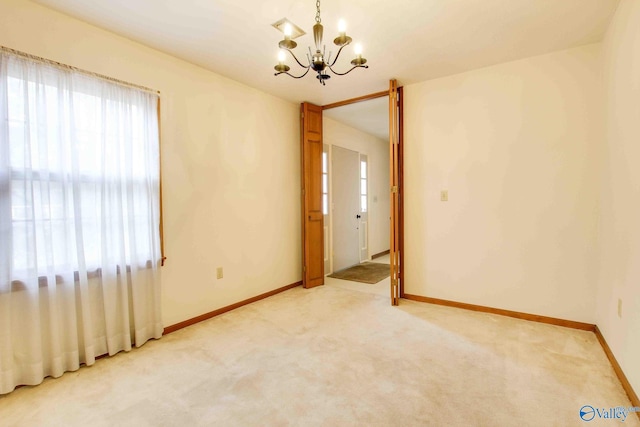 empty room with carpet flooring and a chandelier