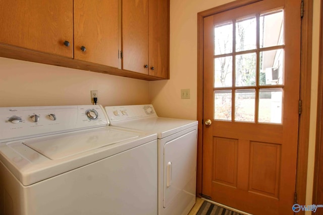 clothes washing area featuring washing machine and clothes dryer and cabinets