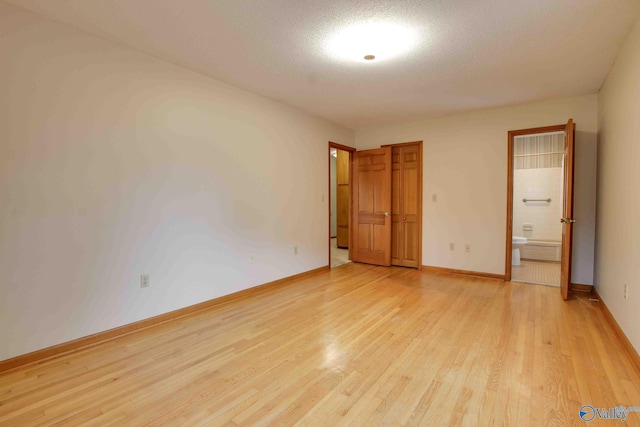 unfurnished bedroom with a textured ceiling and light hardwood / wood-style floors