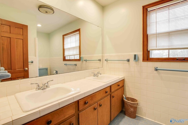 bathroom with tile patterned flooring, vanity, and tile walls