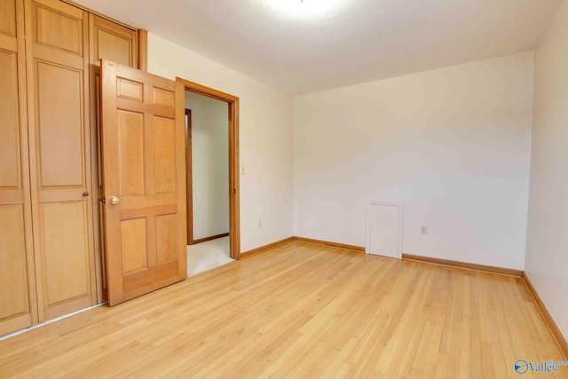 unfurnished bedroom featuring light hardwood / wood-style flooring and a textured ceiling