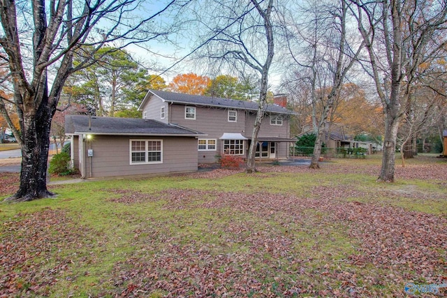 rear view of house with a patio area and a lawn