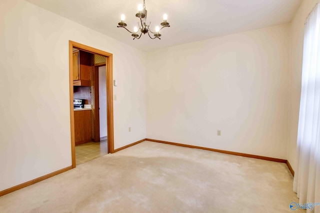 empty room featuring a chandelier and light carpet