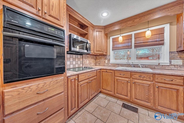 kitchen with light countertops, visible vents, a sink, a textured ceiling, and black appliances