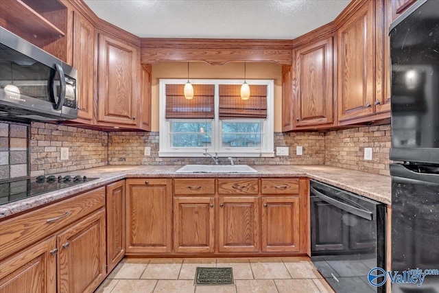 kitchen with black appliances, brown cabinets, and a sink