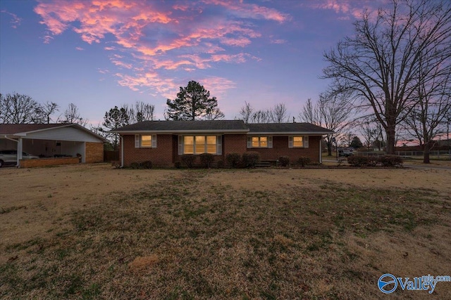 ranch-style home featuring brick siding and a front lawn