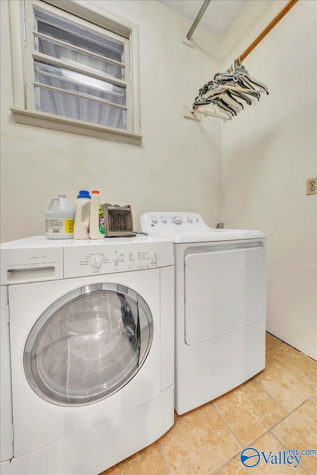 clothes washing area with laundry area, washer and clothes dryer, and light tile patterned floors