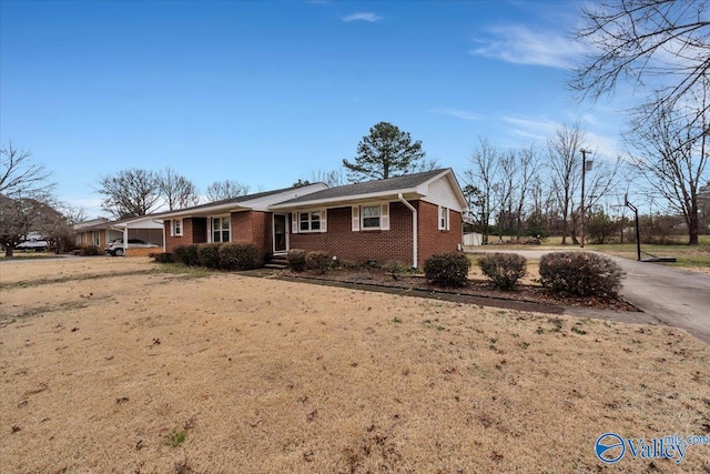 single story home featuring aphalt driveway and brick siding