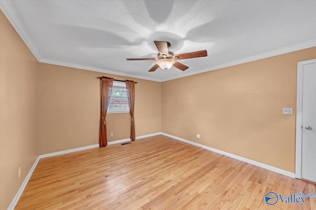 spare room with baseboards, a ceiling fan, a textured ceiling, crown molding, and light wood-style floors