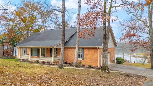 view of front of property with a porch, a water view, and a front lawn