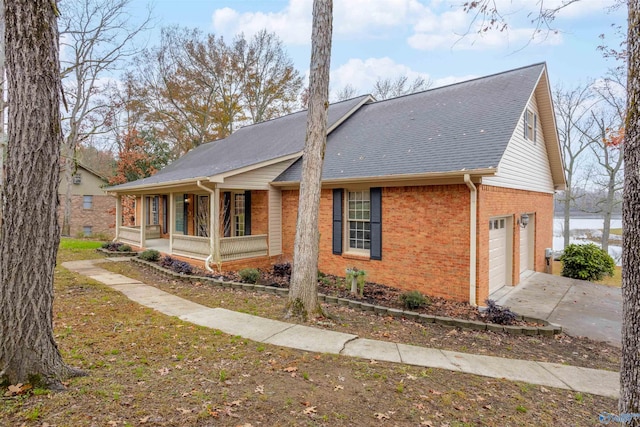 view of side of property featuring a porch, a garage, and a water view