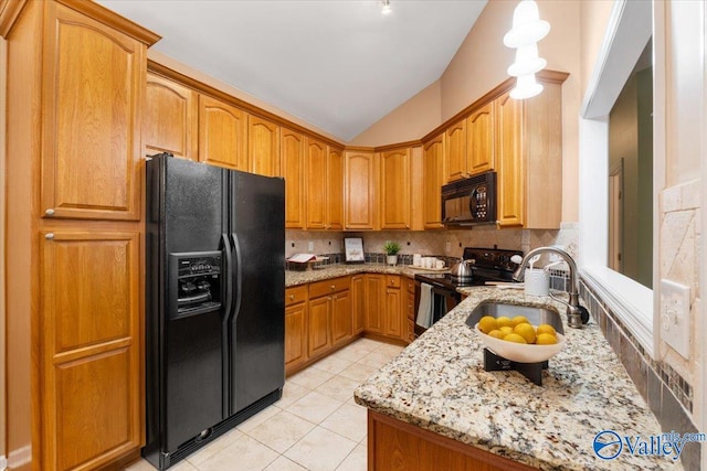 kitchen featuring light stone counters, backsplash, light tile patterned floors, black appliances, and lofted ceiling