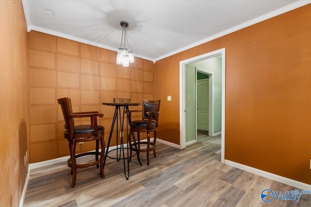 dining area with ornamental molding and hardwood / wood-style floors