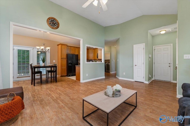 living room featuring ceiling fan with notable chandelier, light wood-type flooring, and lofted ceiling