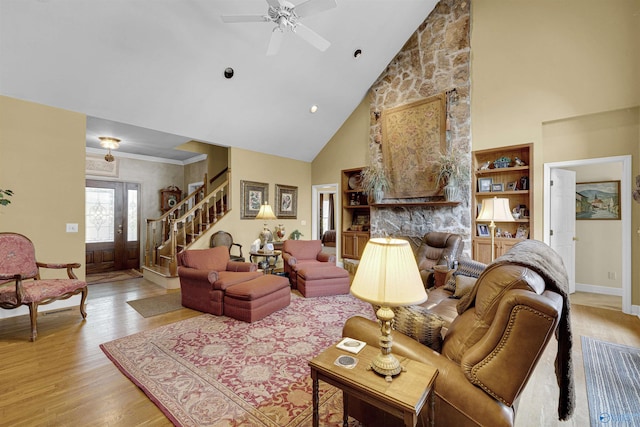 living room featuring ceiling fan, high vaulted ceiling, light hardwood / wood-style floors, and a stone fireplace