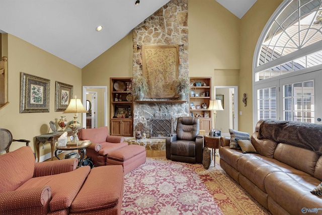 living room with high vaulted ceiling and a stone fireplace