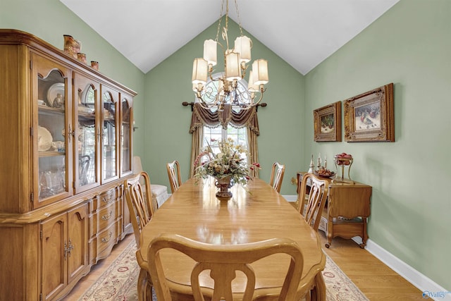 dining area featuring a notable chandelier, light hardwood / wood-style floors, and lofted ceiling