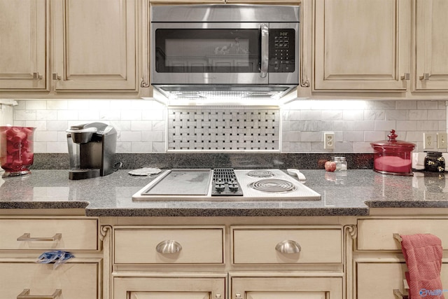 kitchen with electric stovetop, tasteful backsplash, and light brown cabinetry