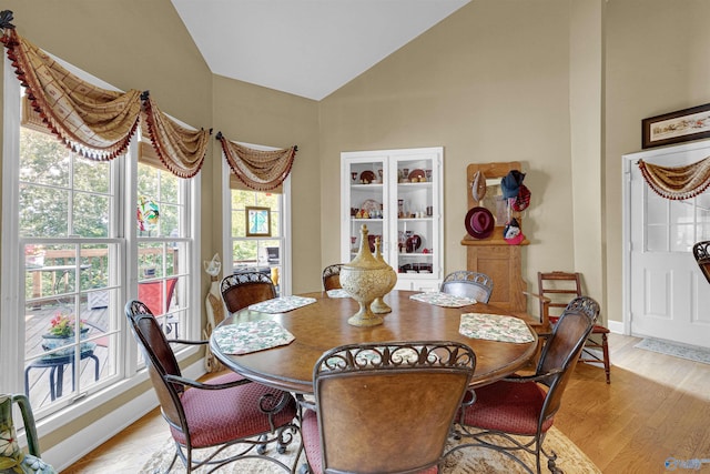 dining room with light hardwood / wood-style floors and vaulted ceiling