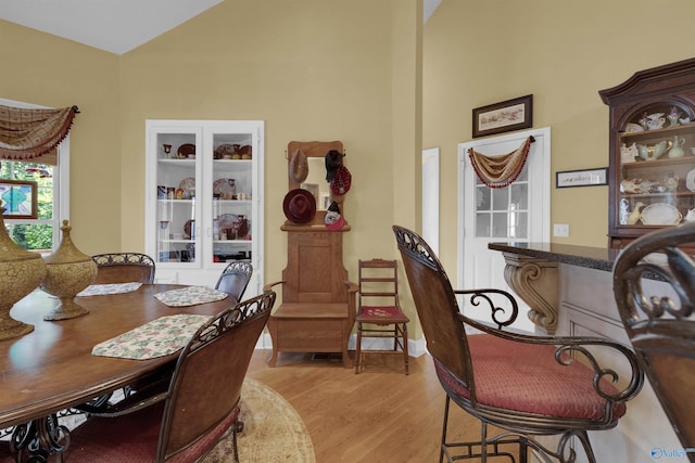 dining room with light hardwood / wood-style floors and a high ceiling