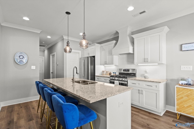 kitchen with white cabinets, a kitchen island with sink, and appliances with stainless steel finishes