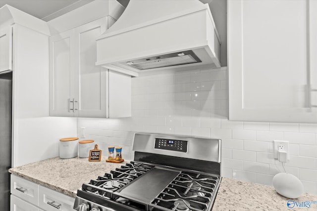 kitchen with custom range hood, stainless steel appliances, and white cabinetry