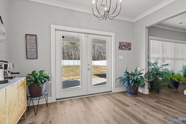 doorway to outside with crown molding, french doors, light hardwood / wood-style floors, and a notable chandelier