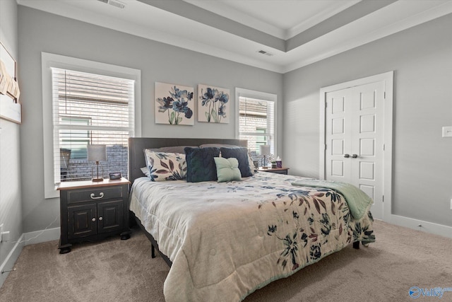 bedroom featuring a raised ceiling, light colored carpet, and ornamental molding