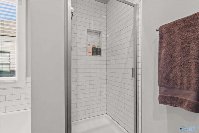 bathroom featuring a tile shower and a wealth of natural light