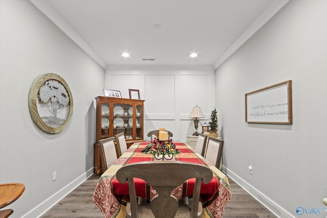 dining area with dark hardwood / wood-style flooring and crown molding