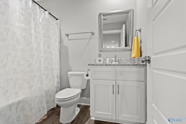 bathroom with hardwood / wood-style floors, vanity, toilet, and walk in shower