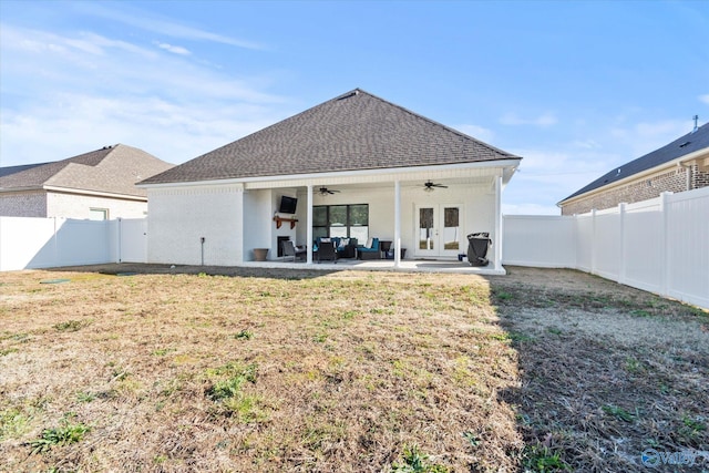 rear view of property featuring french doors, a patio, ceiling fan, and a lawn