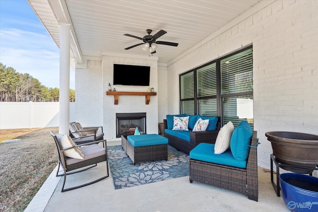 view of patio / terrace featuring an outdoor living space with a fireplace and ceiling fan