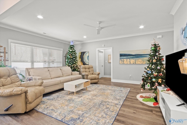 living room featuring hardwood / wood-style floors, ceiling fan, and crown molding