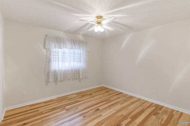 empty room featuring a textured ceiling, ceiling fan, and light wood-type flooring