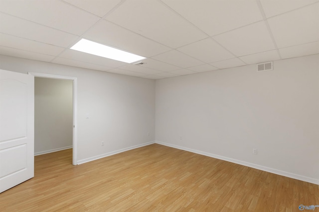 unfurnished room with light hardwood / wood-style flooring and a drop ceiling